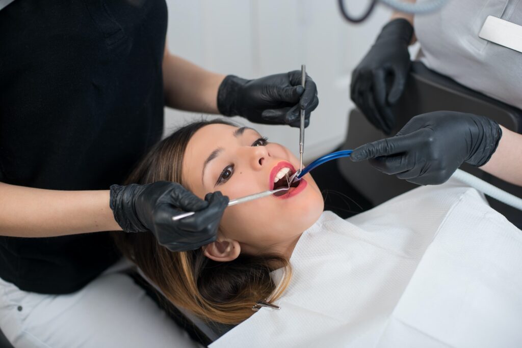 Beautiful young woman having dental check up in dental office. Dentistry